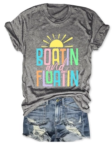 Detail of grey Boatin and Floatin t-shirt with knotted hem and distressed denim shorts
