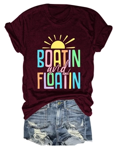 Flat lay of burgundy BOATIN and FLOATIN graphic t-shirt with ripped denim shorts