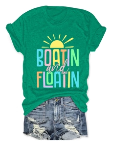 Flat lay of green Boatin and Floatin short sleeve T-shirt with denim shorts