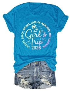 Flat lay di maglietta blu Girls Trip 2026 con stampa tropicale e pantaloncini
