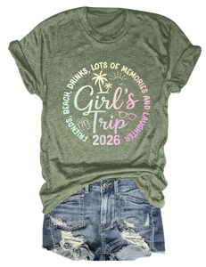 Dettaglio flat lay della maglietta verde Girls Trip 2026 e pantaloncini in denim strappati