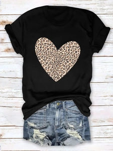 Flat lay of black T-shirt with leopard heart print and distressed denim shorts