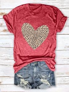 Flat lay of women's casual red T-shirt with leopard heart print and distressed denim shorts