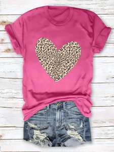 Flat lay of women's hot pink T-shirt featuring a leopard heart print and denim shorts