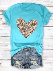 Detail of distressed denim shorts with frayed edges and light blue leopard heart t-shirt