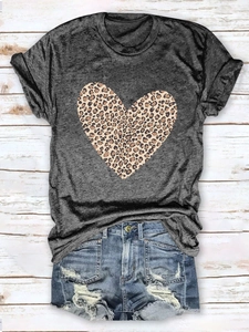 Flat lay of gray crew neck T-shirt with leopard print heart and denim shorts on wood