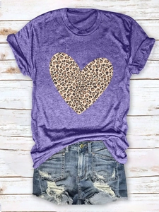 Flat lay of purple cotton T-shirt featuring a leopard print heart on a wood background