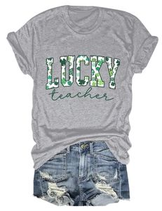 Flat lay of gray St. Patrick's Day T-shirt with clover print and frayed denim shorts