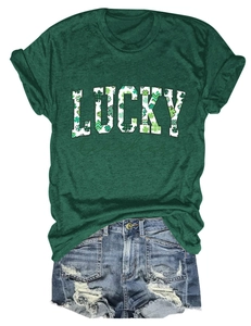 Flat lay of green Lucky Teacher T-shirt with shamrock print and ripped denim shorts