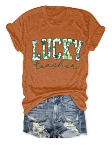 Detail of St. Patrick's Day orange t-shirt with Lucky Teacher clover graphic and denim shorts