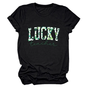 Detail of LUCKY teacher print with green shamrock pattern on a black cotton t-shirt