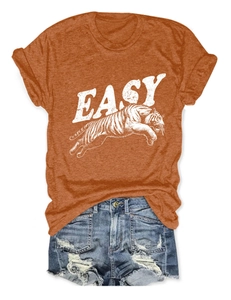 Rust orange cotton T-shirt featuring Easy tiger print paired with distressed blue denim shorts