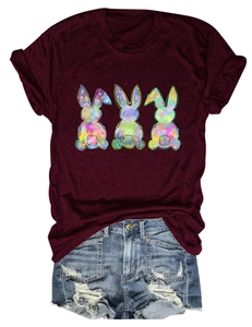 Flat lay of a wine red T-shirt with three bohemian colorful bunny prints and denim shorts