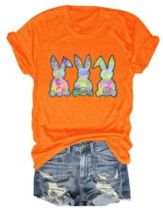 Detailed flat lay of orange T-shirt with three colorful bunnies and ripped denim shorts