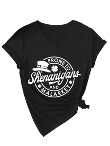 Detail of black V-neck t-shirt featuring St. Patrick's Day graphic and bottom hem knot