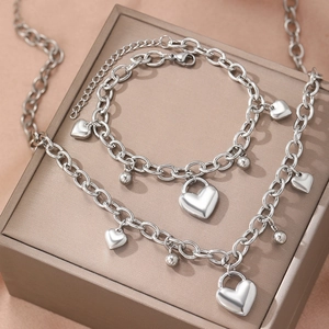 Ensemble collier et bracelet avec pendentif cœur argenté sur un écrin à bijoux