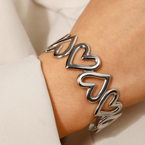 Bracelet jonc ouvert en acier inoxydable argenté avec formes de cœurs creux entrelacés