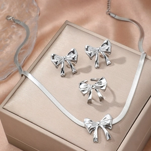 Polished silver bow jewelry set with snake chain necklace, stud earrings, and open ring