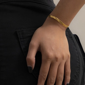 Bracciale a catena piatta a serpente placcato in oro su polso da donna