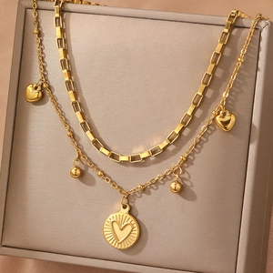 Double layer 18K gold chain necklace with sunburst heart pendant on jewelry display
