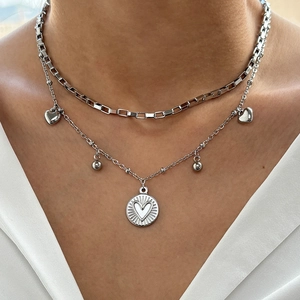 Silver layered necklace with box chain and heart charm pendant on model's neck