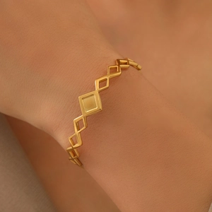 Bracelet ajustable large en acier inoxydable doré avec motifs géométriques losanges évidés
