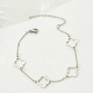 Elegant silver stainless steel bracelet featuring hollow four-leaf clover charms for women
