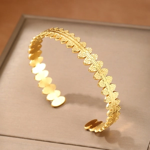 Geometric gold titanium steel open bangle featuring a polished oval fence-style design