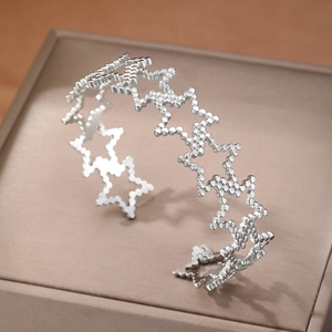 Minimalist silver stainless steel open bangle featuring hollow star patterns and matte finish