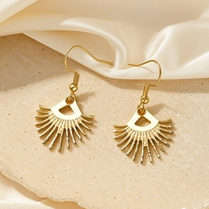 Bohemian gold sunburst earrings with a brushed texture on a cream silk background