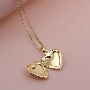 Médaillon coeur plaqué or 18K ouvrant avec compartiment photo sur fond rose minimaliste