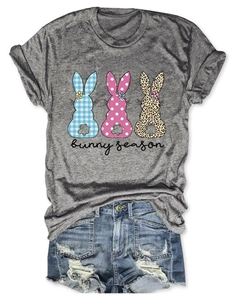 T-shirt gris avec graphismes de lapins et short en jean posés à plat sur fond blanc