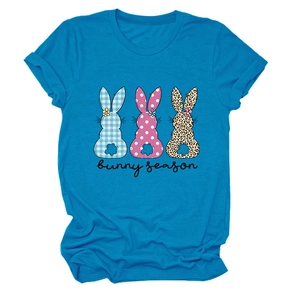 Détail d'un t-shirt bleu avec trois silhouettes de lapin à motifs et pompons duveteux