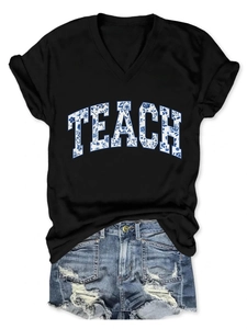 Dettaglio maglietta scollo a V con stampa floreale TEACH e pantaloncini di jeans