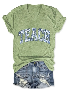 Dettaglio della t-shirt con scollo a V e stampa TEACH floreale e shorts di jeans