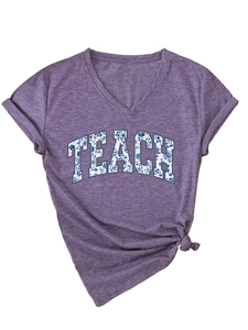 Dettaglio maglietta viola scollo a V con scritte floreali TEACH e nodo laterale moda