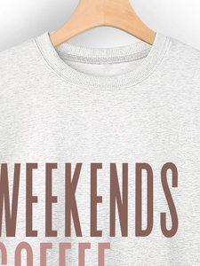 Close-up of the ribbed crew neck and Weekends Coffee print on gray cotton sweatshirt