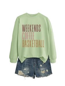 Flat lay of light green sweatshirt with color gradient print and ripped denim shorts