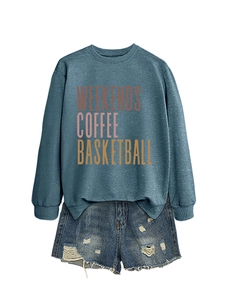 Detail of gray-blue sweatshirt with colorful text print and ripped denim shorts edges