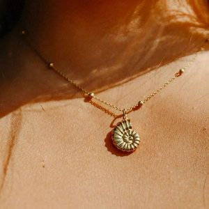 Collier en acier inoxydable plaqué or 18 carats avec pendentif nautile sur le cou