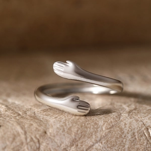 Minimalist silver hug ring with open adjustable band and matte finish on stone