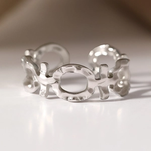 Silver stainless steel open ring with geometric cutouts and hand-hammered texture