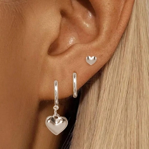 Ensemble de boucles d'oreilles cœur en argent poli porté par un mannequin