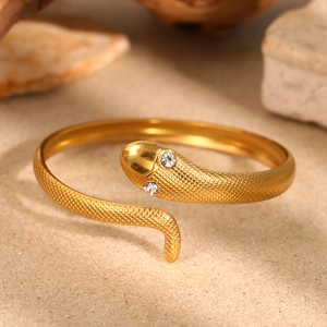 Golden snake-shaped cuff bracelet with detailed scales and sparkling rhinestone eyes