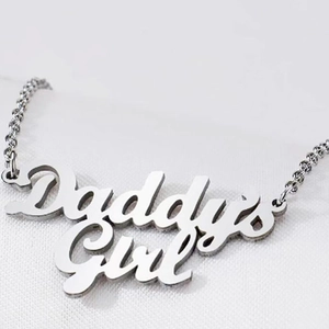 Collier Daddy's Girl argenté avec pendentif artistique sur fond de tissu blanc épuré