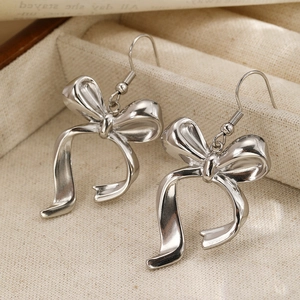 Elegant silver bow earrings in titanium steel displayed on a premium jewelry box