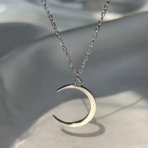 Minimalistische silberne Mond-Halskette mit poliertem Finish auf grauem Seidenhintergrund