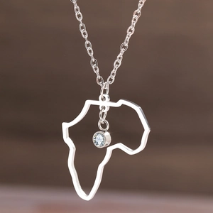 Collier carte Afrique argentée avec pierre de zircon sur fond bokeh chaleureux