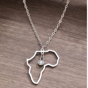 Collier argenté avec pendentif carte de l'Afrique et zircon sur fond en bois rustique