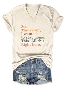 Flat lay of a beige V-neck slogan T-shirt paired with distressed denim blue shorts